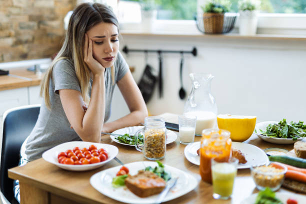 Depressed young  woman doesn't want to eat her breakfast